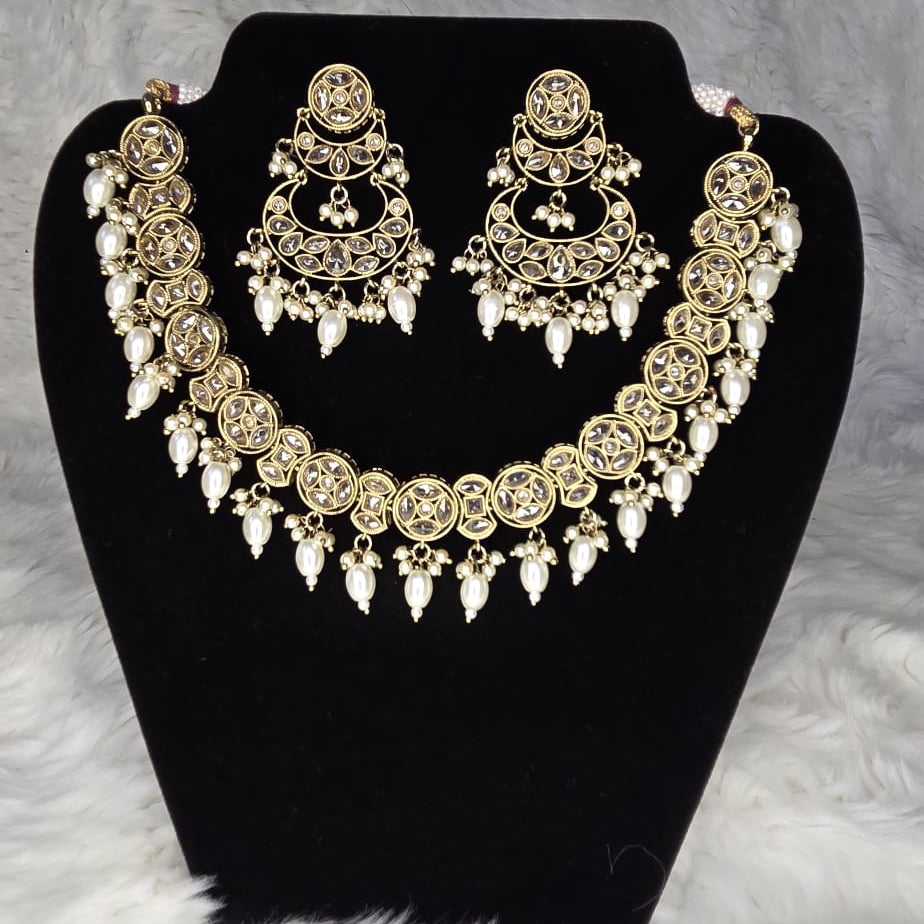 Jewelry set with necklace and earrings on a black stand against a gray background